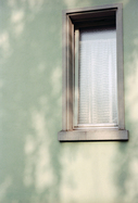 Blassgrüne Hauswand mit Fenster
